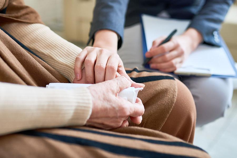 A counselor supporting a patient by holding their hands